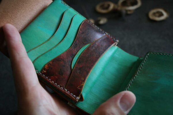 レッドピックガードのような差し色が入ったターコイズ革財布
