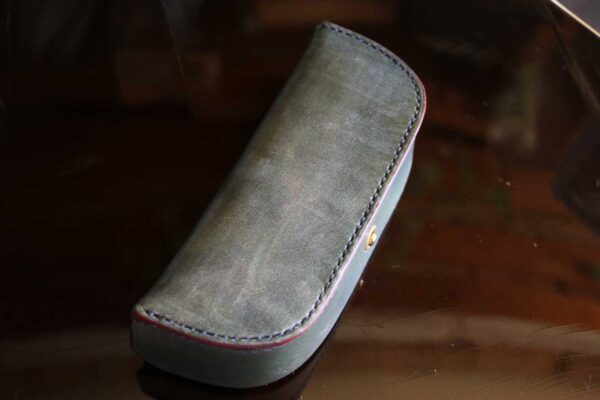 一点物のThe Crescent Moon Glasses case。オリーブグレーを基調に、革本来の風合いを活かしたヴィンテージテイストの本革メガネケース。