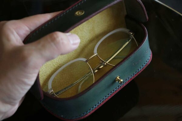 一点物のThe Crescent Moon Glasses case。オリーブグレーを基調に、革本来の風合いを活かしたヴィンテージテイストの本革メガネケース。