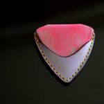 鮮やかなピンクとライトパープルの手染めレザーにイエローステッチを合わせた1点もののピック型ギターピックケース