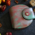 ピンクとターコイズグリーンのヴィンテージカラーが特徴的な一点もののレザーコンパクトウォレット